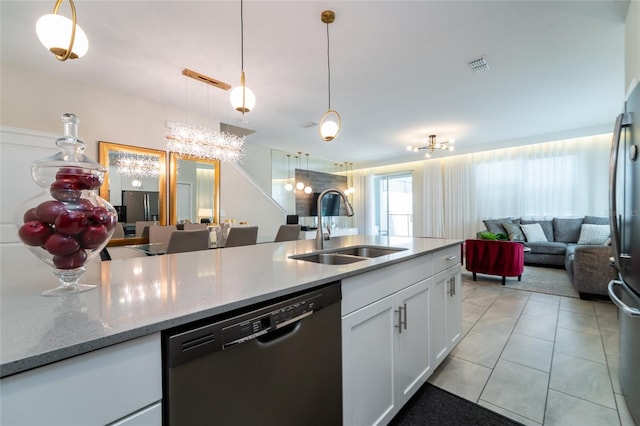 kitchen featuring light stone countertops, sink, hanging light fixtures, stainless steel appliances, and white cabinets