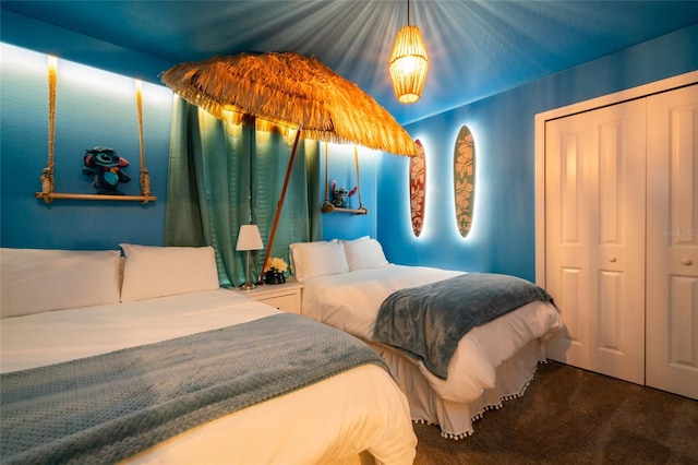 carpeted bedroom with vaulted ceiling and a closet