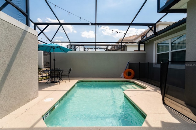 view of swimming pool featuring a patio area and a lanai