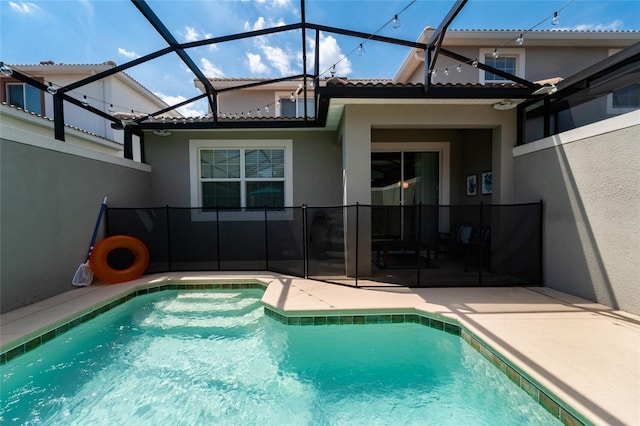 view of swimming pool with a patio area and a lanai