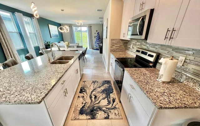 kitchen featuring appliances with stainless steel finishes, decorative light fixtures, and white cabinetry