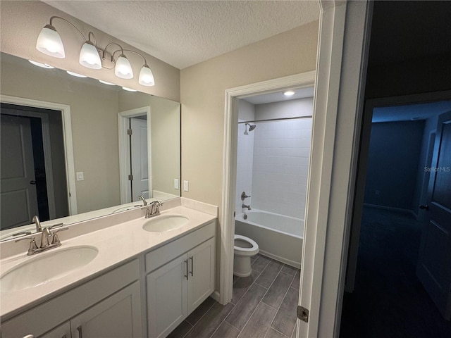 full bathroom featuring toilet, shower / tub combination, vanity, and a textured ceiling