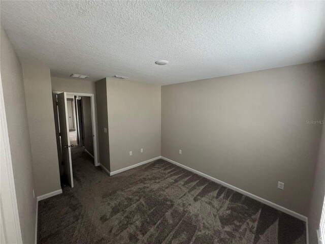 carpeted spare room with a textured ceiling