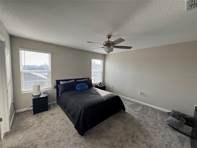 carpeted bedroom with a textured ceiling and ceiling fan