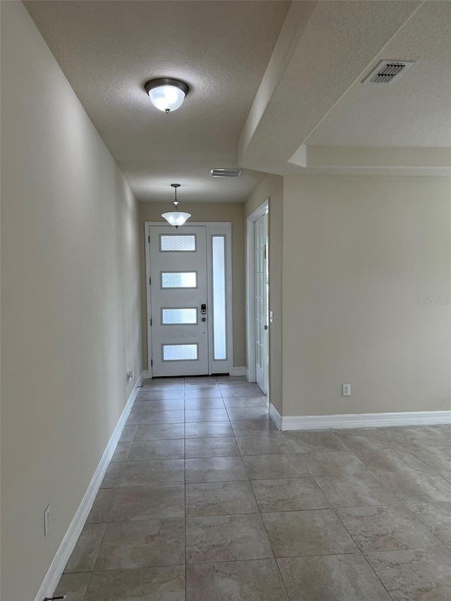 foyer entrance featuring a textured ceiling