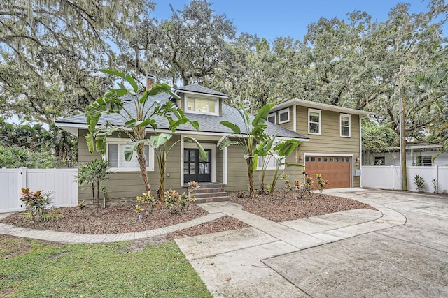 734 S Mills Ave, Orlando, FL 32801 - view of front of house featuring a chimney, a garage, fence, concrete driveway, and a shingled roof
