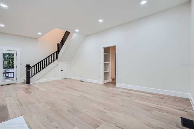 734 S Mills Ave, Orlando, FL 32801 - unfurnished living room with baseboards, light wood finished floors, stairs, and visible vents
