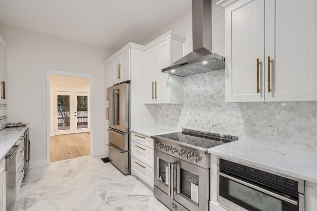 734 S Mills Ave, Orlando, FL 32801 - kitchen with wall chimney range hood, french doors, high end appliances, light stone counters, and white cabinets