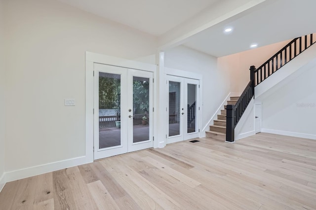 interior space with french doors, beam ceiling, and light wood-type flooring