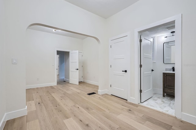 734 S Mills Ave, Orlando, FL 32801 - interior space featuring visible vents, arched walkways, light wood-type flooring, baseboards, and ensuite bath