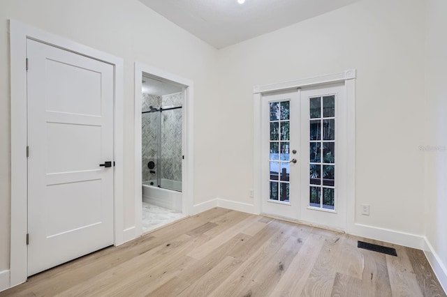 empty room with french doors and light hardwood / wood-style flooring