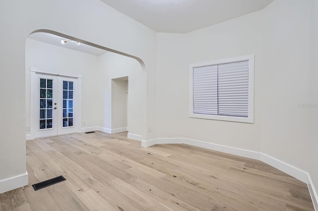 unfurnished room with french doors and light wood-type flooring