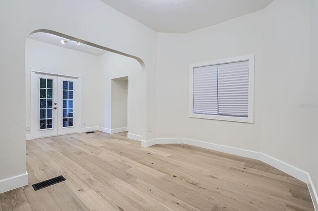 734 S Mills Ave, Orlando, FL 32801 - empty room with french doors, arched walkways, light wood-style floors, and visible vents