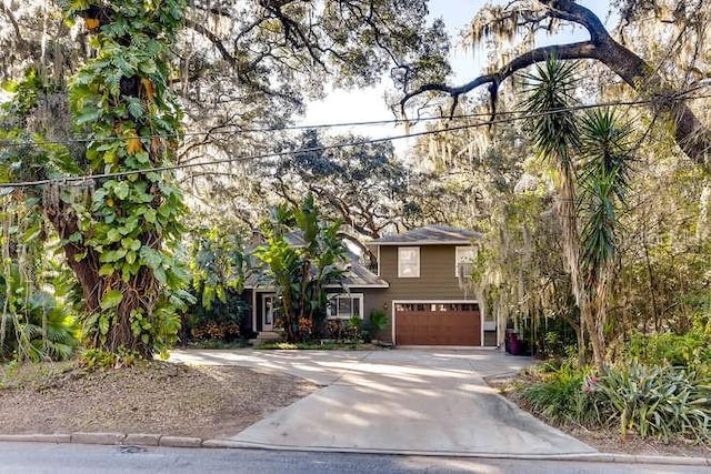 view of property hidden behind natural elements featuring a garage