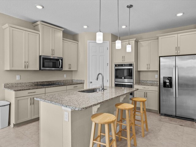 528 Bellissimo Pl, Howey In The Hills, FL 34737 - kitchen with a kitchen bar, a sink, stainless steel appliances, a kitchen island with sink, and light stone counters