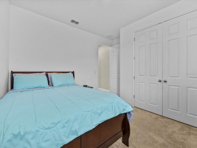 528 Bellissimo Pl, Howey In The Hills, FL 34737 - bedroom with light carpet, a closet, and visible vents