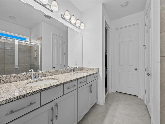 528 Bellissimo Pl, Howey In The Hills, FL 34737 - full bathroom featuring double vanity, tile patterned flooring, a shower stall, and a sink