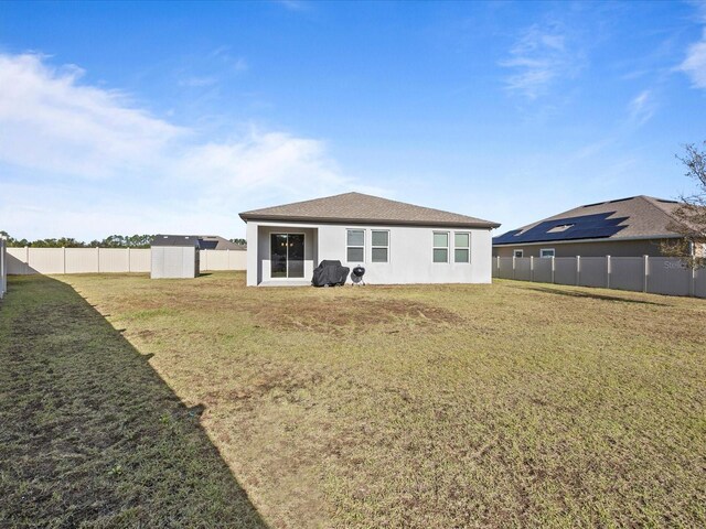 528 Bellissimo Pl, Howey In The Hills, FL 34737 - back of property with a yard, stucco siding, and a fenced backyard