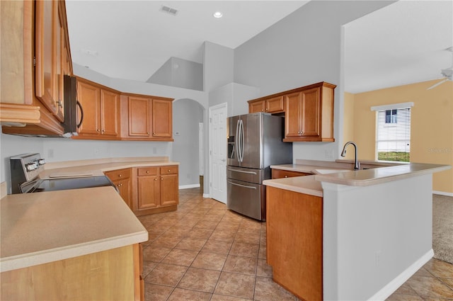 kitchen with kitchen peninsula, sink, high vaulted ceiling, ceiling fan, and appliances with stainless steel finishes