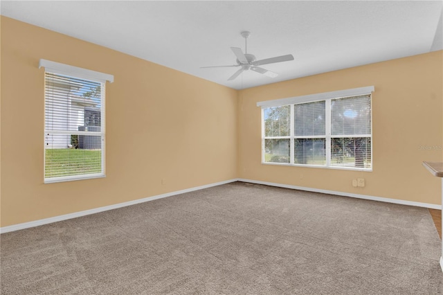 carpeted empty room featuring ceiling fan and plenty of natural light