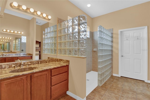 bathroom with vanity, tile patterned floors, and a tile shower