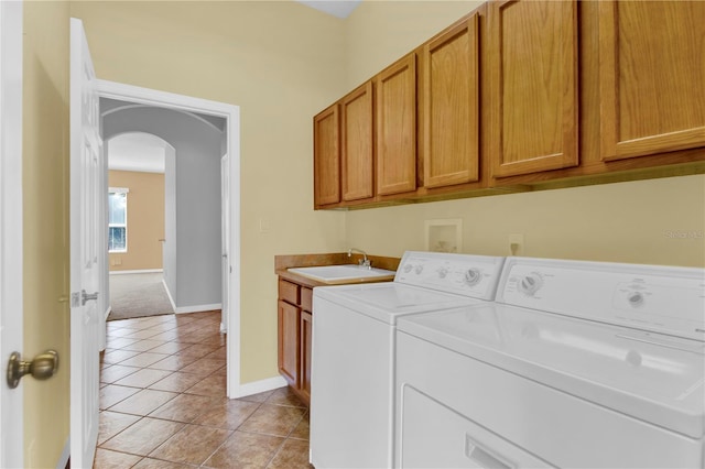 laundry room with cabinets, washing machine and dryer, sink, and light tile patterned floors