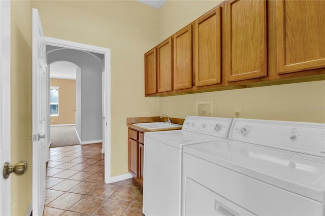 4538 Nottoway Dr, Leesburg, FL 34748 - laundry room featuring light tile patterned floors, a sink, arched walkways, separate washer and dryer, and cabinet space