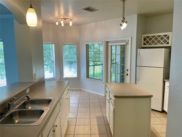 kitchen featuring white cabinets, sink, pendant lighting, and white appliances