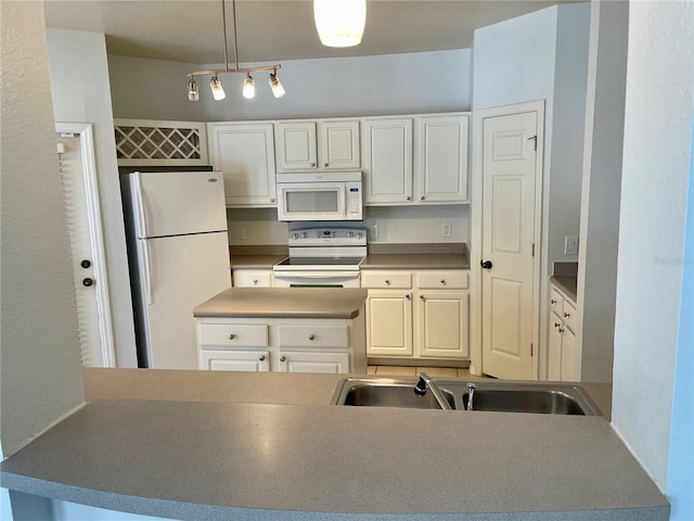 kitchen featuring white appliances, white cabinets, sink, and hanging light fixtures