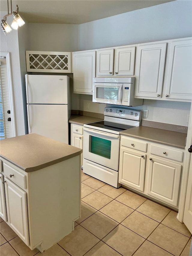 kitchen with white appliances, white cabinetry, light tile patterned floors, and hanging light fixtures