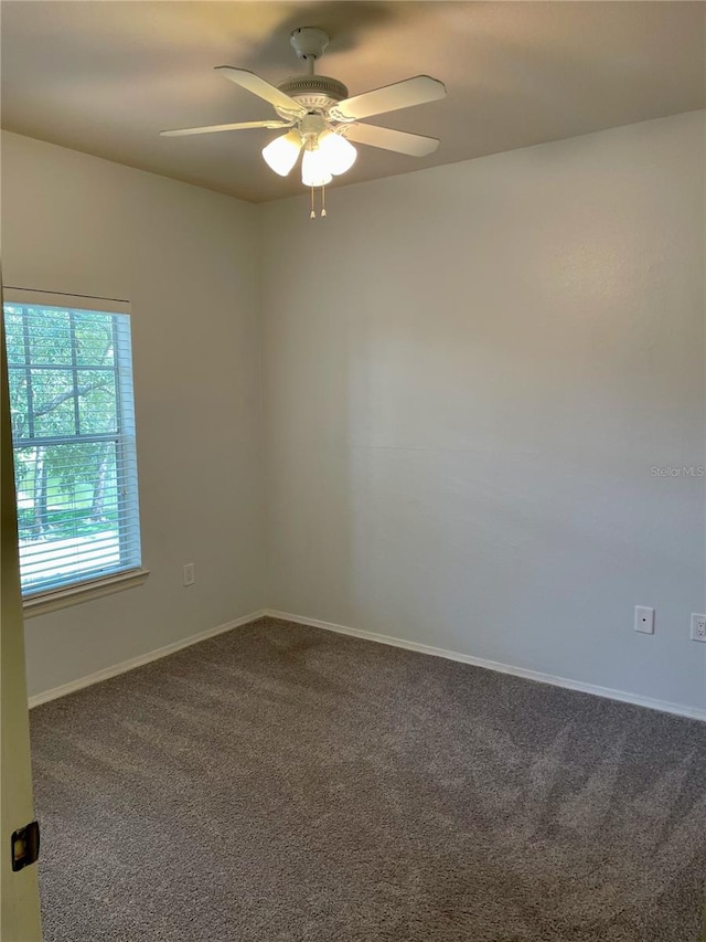 carpeted spare room featuring ceiling fan