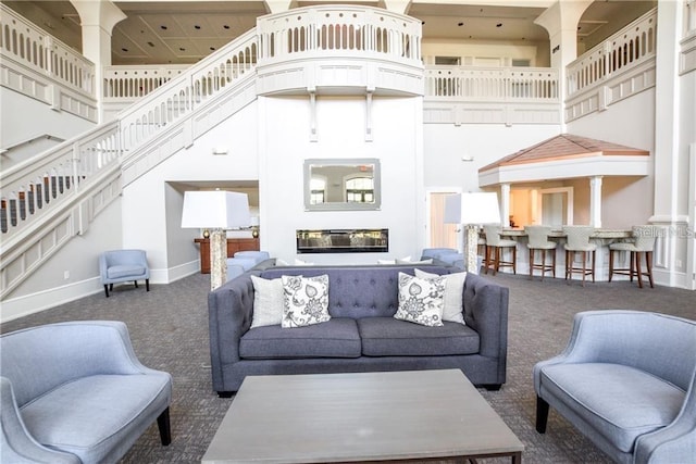 carpeted living room featuring a towering ceiling