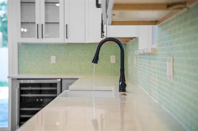 interior space featuring white cabinets, wine cooler, and backsplash