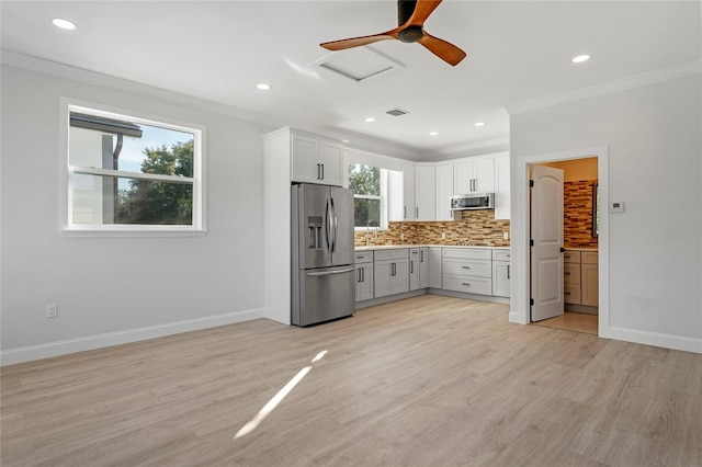 kitchen featuring white cabinets, crown molding, light hardwood / wood-style floors, and stainless steel appliances