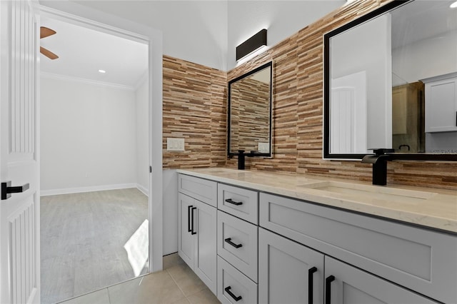 bathroom with hardwood / wood-style floors, decorative backsplash, vanity, ceiling fan, and crown molding