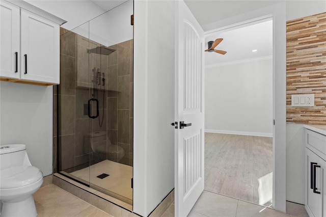 bathroom featuring toilet, hardwood / wood-style floors, wooden walls, ornamental molding, and an enclosed shower