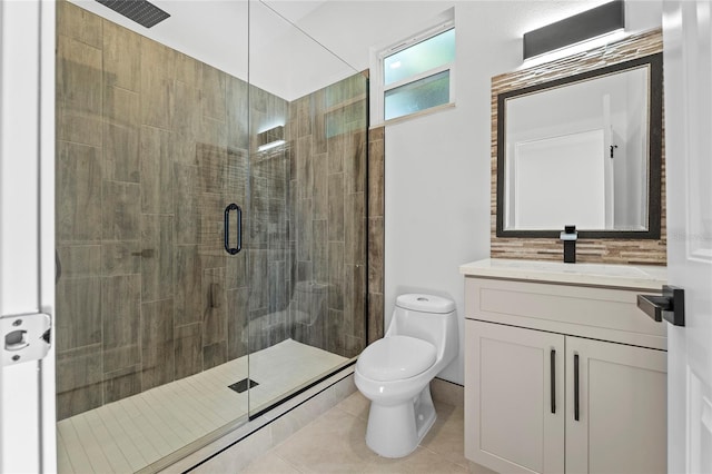 bathroom with a shower with shower door, vanity, toilet, and tile patterned flooring