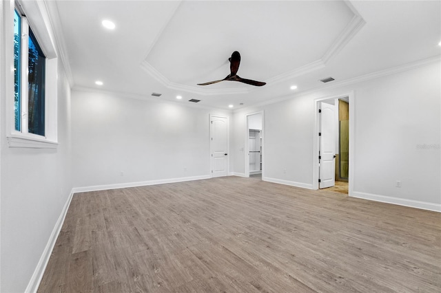 spare room with ornamental molding, light hardwood / wood-style flooring, ceiling fan, and a raised ceiling