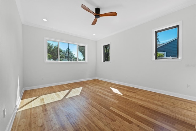 spare room featuring hardwood / wood-style flooring, ceiling fan, and crown molding