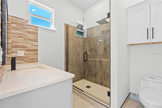 bathroom with vanity, tile patterned floors, toilet, and a shower with shower door