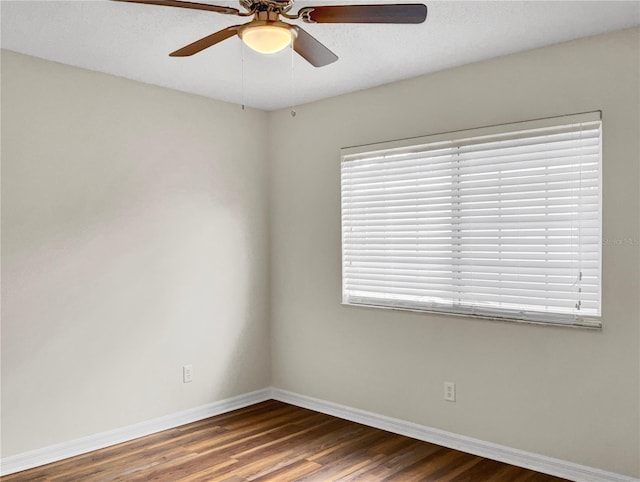 unfurnished room with ceiling fan and dark hardwood / wood-style flooring