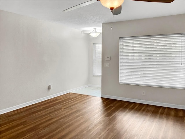 unfurnished room featuring dark wood-type flooring, a textured ceiling, and ceiling fan