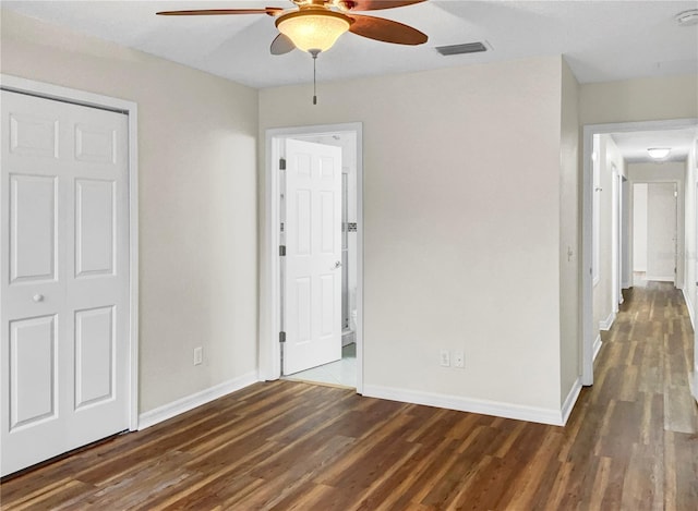 unfurnished bedroom featuring a closet, dark wood-type flooring, and ceiling fan