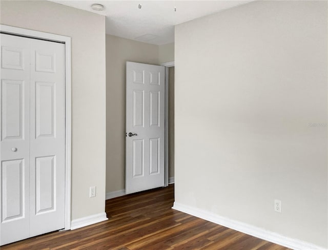 unfurnished bedroom with a closet and dark hardwood / wood-style floors