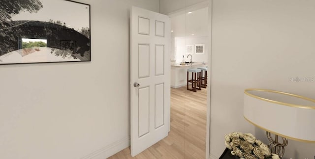 corridor featuring sink and light hardwood / wood-style flooring