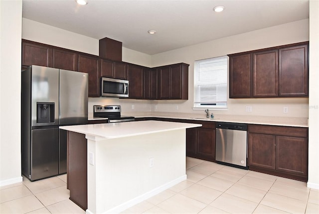 kitchen with sink, appliances with stainless steel finishes, a center island, and dark brown cabinetry