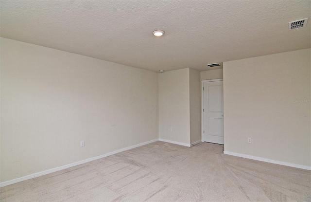 carpeted spare room featuring a textured ceiling