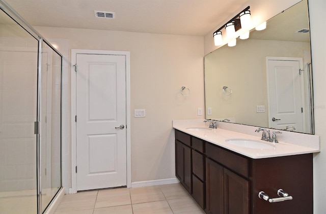 bathroom featuring vanity, a shower with shower door, and tile patterned floors