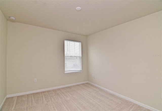 carpeted empty room featuring a textured ceiling