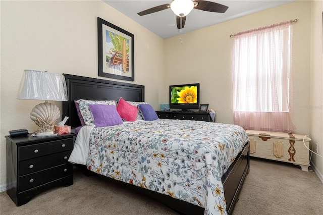 bedroom featuring ceiling fan, multiple windows, and light colored carpet